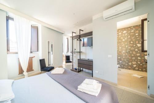 a white bedroom with a bed and a piano at L'AFFACCIO in Catania