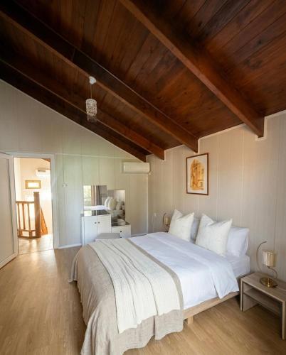 a bedroom with a large white bed with a wooden ceiling at Chalet duplex N 7 avec piscine in Bouzareah
