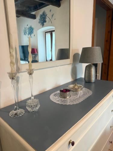 eine Kommode mit zwei Gläsern und einer Lampe darauf in der Unterkunft Mameli 27 in Spoleto