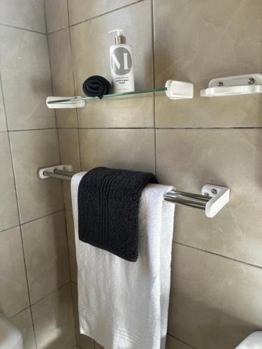 a bathroom with a towel hanging on a towel rack at Muizenberg Surfers Lodge in Muizenberg