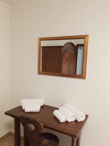 a mirror on a wall above a wooden table with towels at Le vigne in Asti