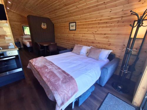 a bedroom with a bed in a wooden room at Blackstairs Glamping Pod 1 in Killann