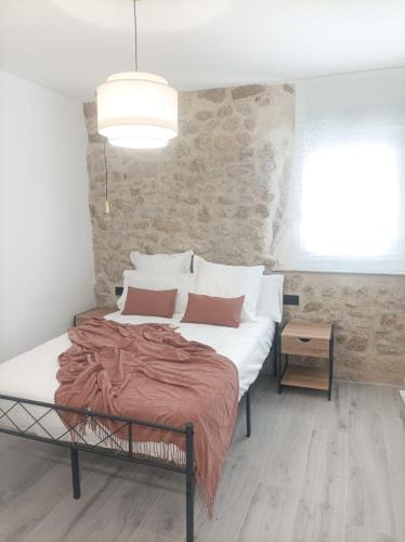 a bedroom with a large bed with white sheets and pillows at El Loft de Cris in Béjar