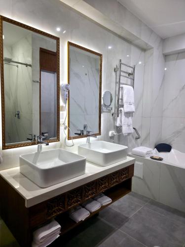 a bathroom with two sinks and a large mirror at Alpacaterra Machupichu Hotel in Machu Picchu
