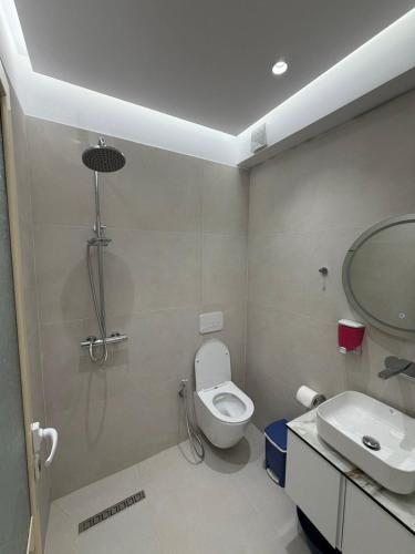 a bathroom with a shower and a toilet and a sink at Rei Apartments in Sarandë