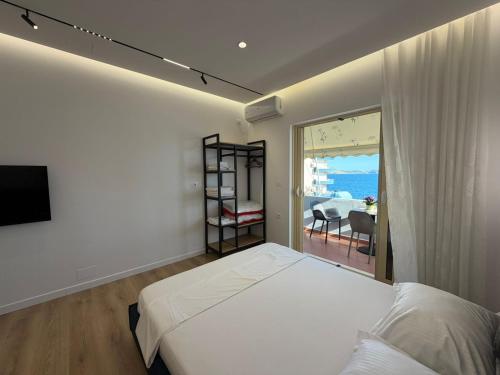 a bedroom with a bed and a view of the ocean at Rei Apartments in Sarandë
