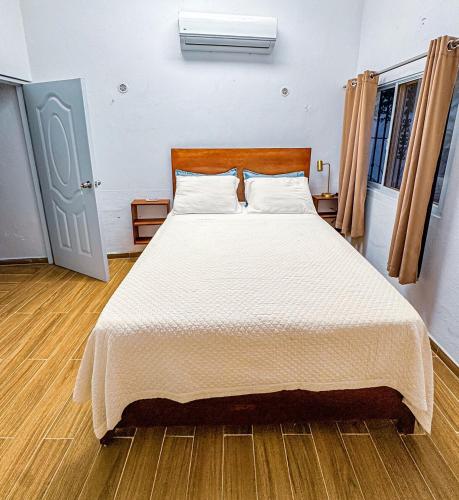 a bedroom with a large bed with a white comforter at Villa La Dueña Las Terrenas in Las Terrenas