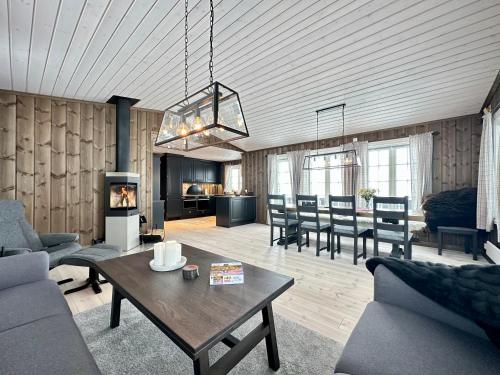 a living room with a couch and a table at High-standard cabin with jacuzzi & stunning views in Øyer