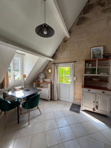 a kitchen with white cabinets and a table and chairs at LES TERRASSES (centre de Pierrefonds) in Pierrefonds