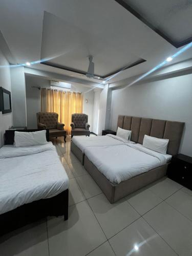 a hotel room with two beds and a couch at We Hotels in Islamabad