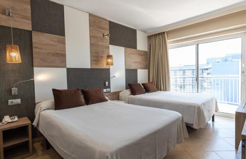 ein Hotelzimmer mit zwei Betten und einem Fenster in der Unterkunft Hotel Cesar Augustus in Cambrils