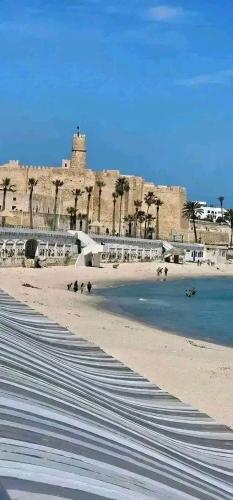 a group of people on a beach near the water at Résidence Nour in Monastir