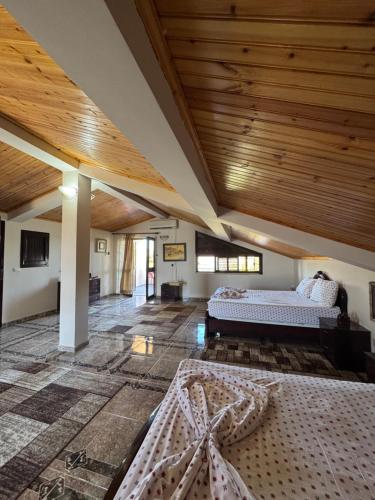 a bedroom with two beds and a wooden ceiling at Villa Velipoj in Velipojë
