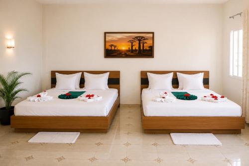 a bedroom with two beds with flowers on them at Hotel National Ambanja in Ambanja