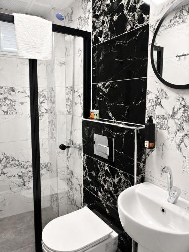a black and white bathroom with a toilet and a sink at Kaya Hotel in Antalya