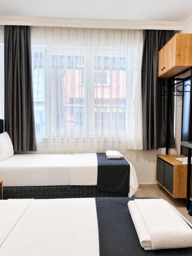 a hotel room with two beds and a window at Kaya Hotel in Antalya