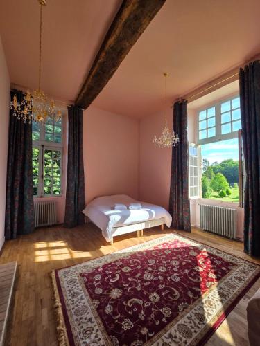 a bedroom with a bed and a large window at Château de Beaumanoir in Évran