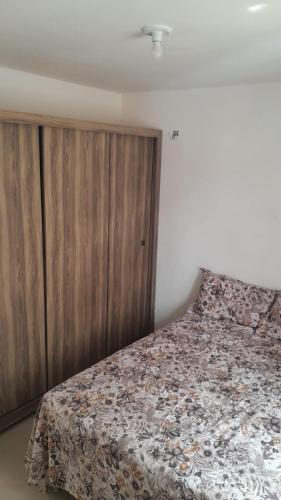 a bedroom with a bed and a wooden cabinet at AP da Vicky 2 quartos central São Luis in São Luís