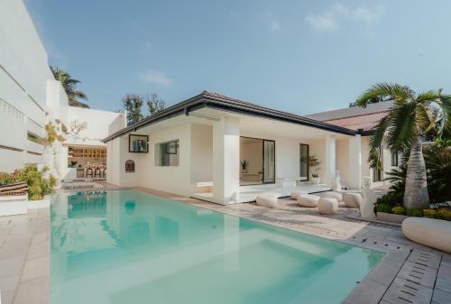 a swimming pool in front of a house at Salt & Palm Villa in Maggona West