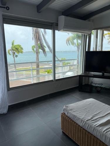 a bedroom with a bed and a view of the ocean at JPY S Suite in Pointe-à-Pitre