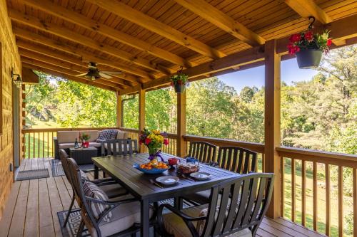 a wooden deck with a table and chairs at Beaver Rock Lodge in Elk Park