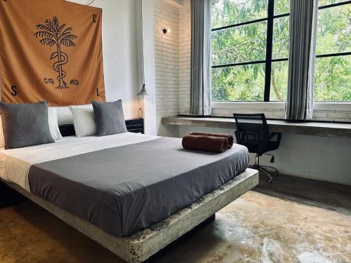 a bedroom with a bed with a chair and windows at REZ SPACE Apartment 05 in Hiriketiya