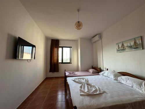 a bedroom with two beds and a window at La Famiglia Villa in Velipojë