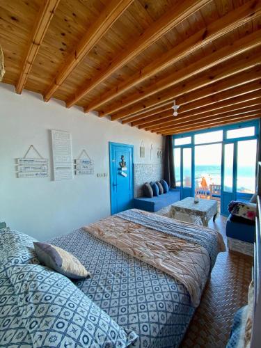 a bedroom with two beds and a blue door at Grotte pied dans l'eau in Aglou