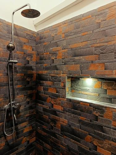 a brick wall in a bathroom with a shower at ITALIAN GUEST in Trincomalee