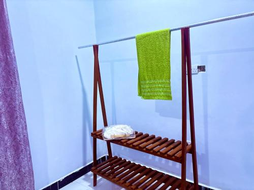 a bathroom with a shower with a bench and a towel at Zanzibar Apartment 1 in Kibele
