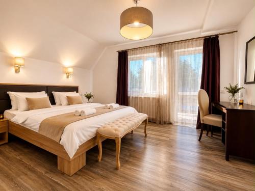a bedroom with a large bed and a desk at Pensiunea Mirage in Iaşi