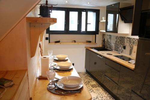 a kitchen with a table with plates and dishes on it at Près de l'aéroport in Ossun