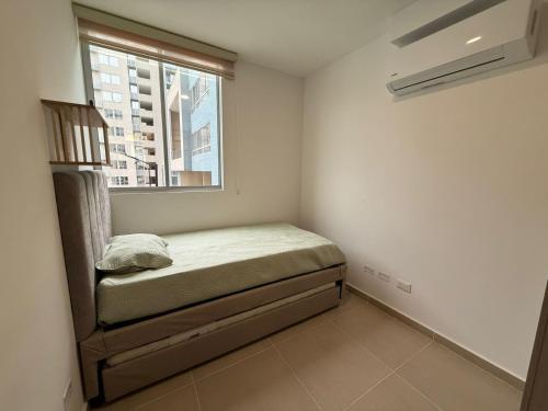 a small bed in a room with a window at Country Reservado in Gaira