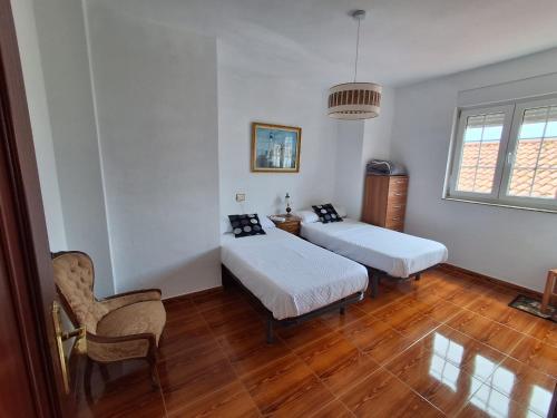 a room with two beds and a chair in it at Las 4 columnas (MFA) in Muxia