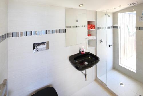 a bathroom with a black sink and a window at The Nikau Loft in Onetangi