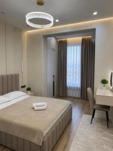 a large bedroom with a large bed and a desk at Современные 2-комнатные апартаменты в ЖК Capital City рядом с Shym City Park in Shymkent
