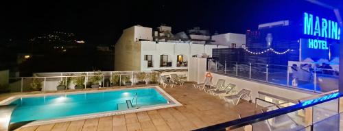 a swimming pool on the roof of a building at night at Hotel Marina in Roses