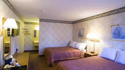 a hotel room with two beds and a bathroom at Value Inn Harrisburg-York in Valley Green