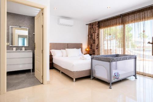 a bedroom with a bed and a sink and a mirror at Villa Hilary in Playa de Muro