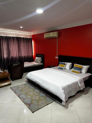 ein Schlafzimmer mit zwei Betten und einer roten Wand in der Unterkunft Solitaire hotel in Lagos