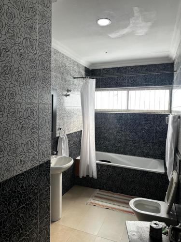 ein Badezimmer mit Badewanne, Toilette und Waschbecken in der Unterkunft Solitaire hotel in Lagos