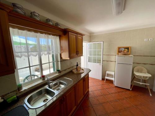 a kitchen with a sink and a refrigerator at Milfontes Villa in Vila Nova de Milfontes