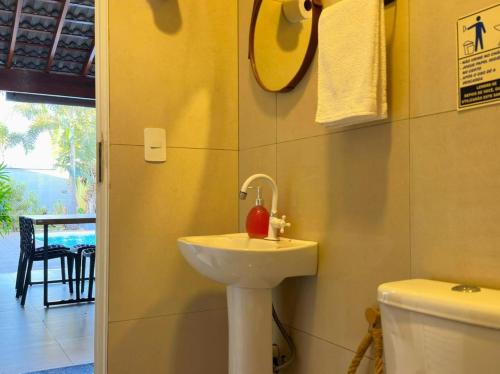 a bathroom with a sink and a toilet at Refúgio com Fogueira, Piscina, Bilhar e Ar condicionado in Nova Odessa