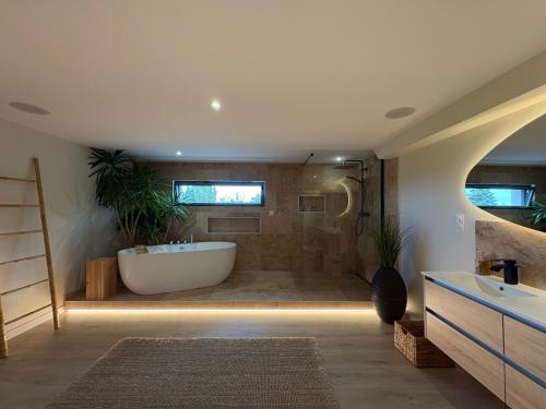 a large bathroom with a tub and a sink at Bergerie bien être in Vaivre-et-Montoille