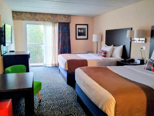 a hotel room with two beds and a desk at Tiki Resort - Lake George in Lake George
