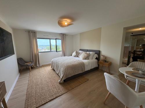 a bedroom with a bed and a living room with a table at Bergerie bien être in Vaivre-et-Montoille