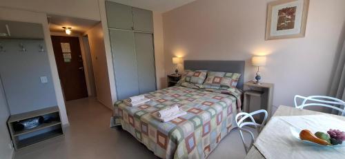 a small bedroom with a bed and a table at El encanto del lago in San Carlos de Bariloche