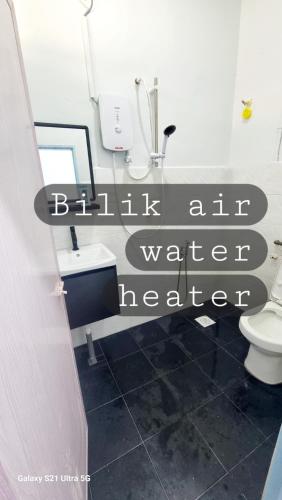 a bathroom with a sign that reads bath all water healer at homestay chendorini cherating in Kampong Chendar