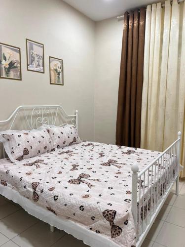 a bedroom with a white bed with a comforter at Elora Homestay in Tampin