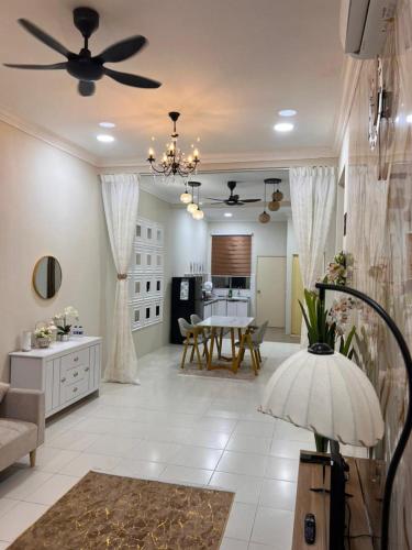 a living room with a ceiling fan and a table at Elora Homestay in Tampin